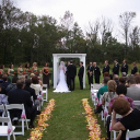 Bride and groom stand beneath a wedding pergola.